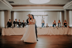 Bride and groom dancing in front of their head table at a waterfront wedding venue near Chicago